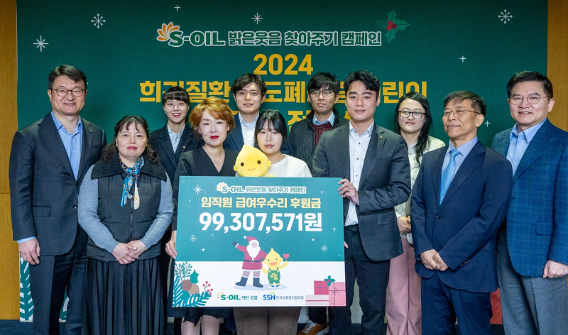 S-OIL 김광남 부문장과 한국사회복지협의회 조남권 사무총장이 2024 희귀질환 담도폐쇄증 어린이 치료비 전달식에서 행사 참석자들과 함께 기념사진을 찍고 있다.